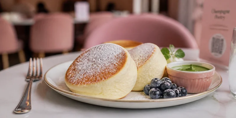 Fluffy Japanese-style souffle pancakes with matcha cream and fresh fruit garnish at a Portland brunch cafe NW 23rd Portland Oregon