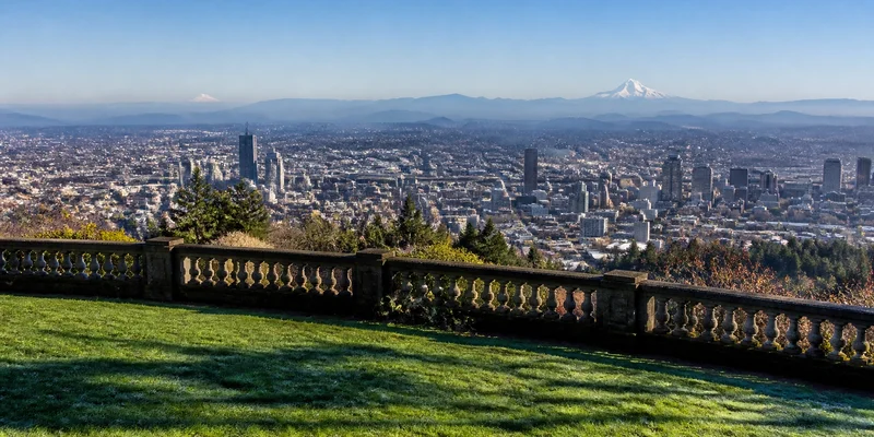 Panoramic clear morning view of Portland skyline Mount Hood and Mount Saint Helens from Pittock Mansion grounds West Hills Portland Oregon
